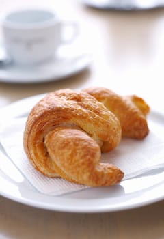 Fresh, delicious croissant on white plate with napkin