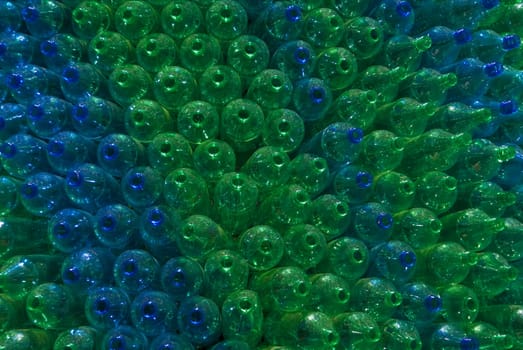 Pile of green and blue empty bottles lined up per color to make an artsy display.