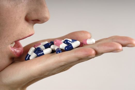 Young woman's hand with colours pills