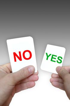 Photo of coloured yes-no cards in hands on a grey background