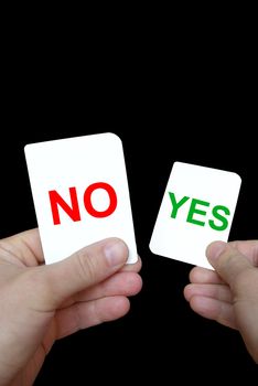 Photo of coloured yes-no cards in hands on a grey background