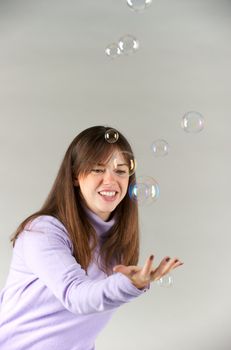 Pretty woman blowing in the soap to create some bubbles