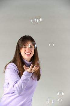 Pretty woman blowing in the soap to create some bubbles