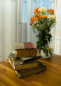 domestic still life with flower in jug and old book