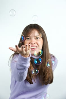 Pretty woman blowing in the soap to create some bubbles