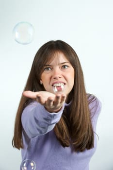 Pretty woman blowing in the soap to create some bubbles