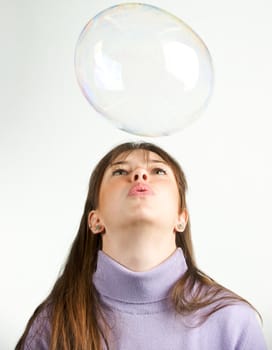 Pretty woman blowing in the soap to create some bubbles