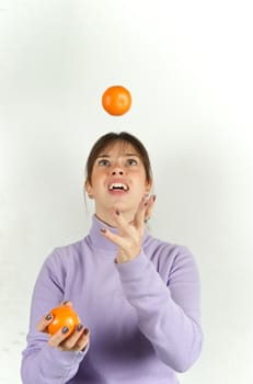 Pretty woman playing with orange fruit