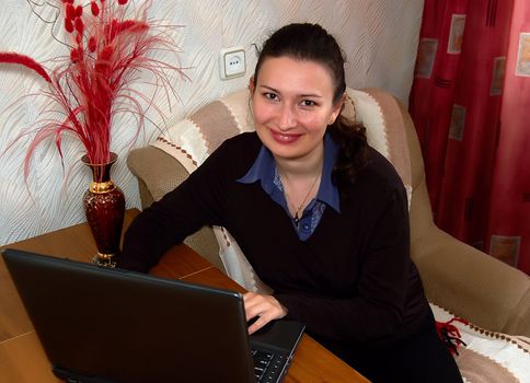 portrait of beautiful brunette women working on laptop (notebook)