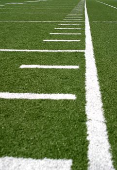 Green football field with large yard markers.