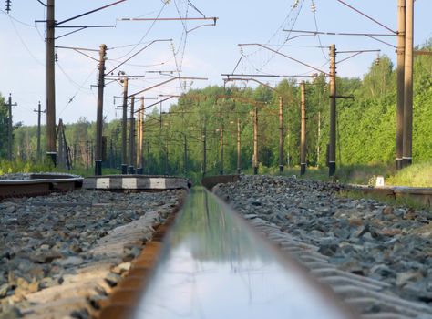 Straight railway track in summer sunrise