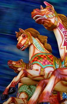 Three horses of a merry-go-round. Focus is on the middle horse.
