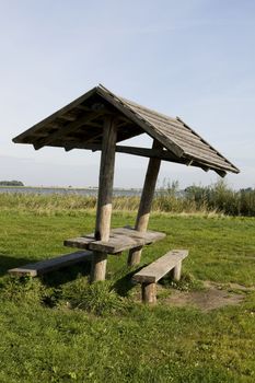 Wooden bower sits empty on a sunny spring day