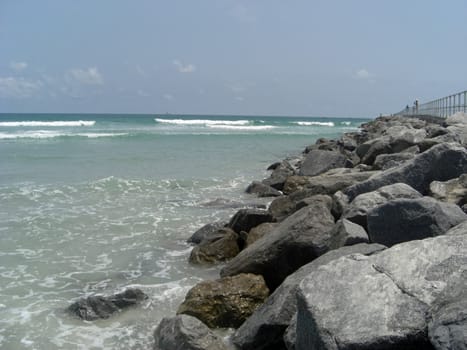 A pile of large rocks are on the edge of the ocean in Ponce Inlet.