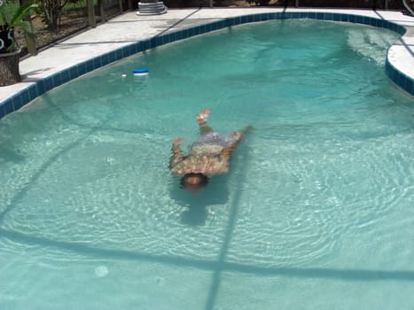 A man is swimming inside an enclosed pool.