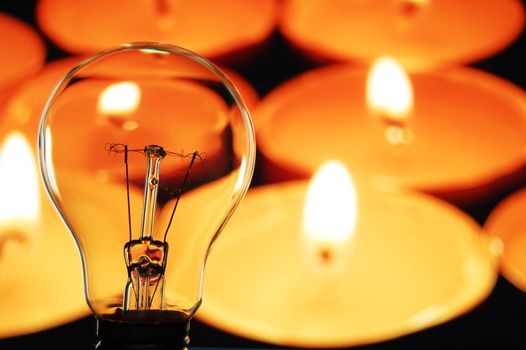 bulb and candle showing concept of saveing anergy