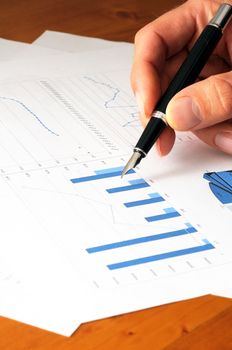 stock market information on paper in office with hand