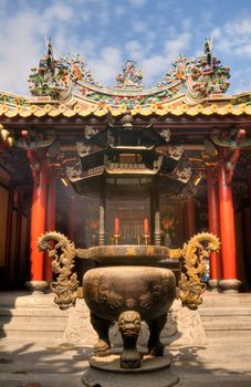 Eastern traditional temple with golden color incense burner in China.