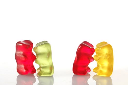 sweet gummy bears dancing on a party on white background
