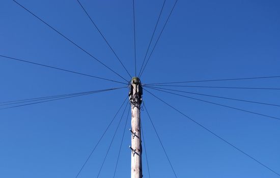 Telephone wires spread out in a circle from the pole