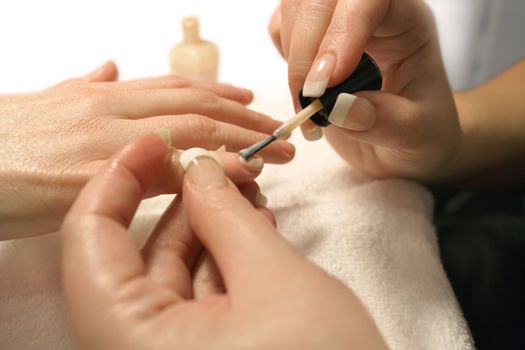 A manicurist applying nail polish during a manicure.
