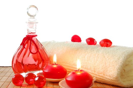 spa decoration with candles and red bottle with massage oil