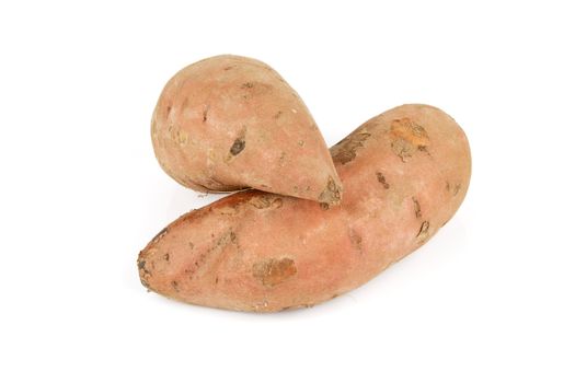 Two raw unpeeled sweet potatoes on a reflective white background