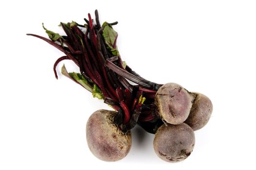 A bunch of raw red beetroot on a reflective white background