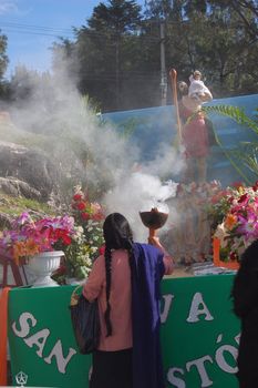 Mayan Indian woman offering incense to saint in Chiapas, Mexico 