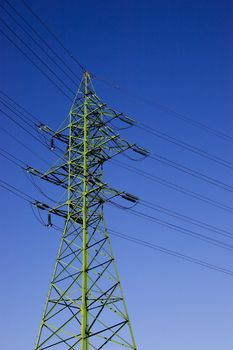 Green high voltage electric line against blue sky