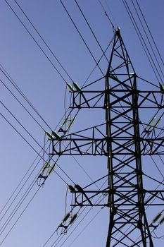 Green high voltage electric line against blue sky