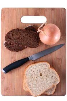 Black bread with onions is separated from a white loaf by a knife on a wooden chopping board.