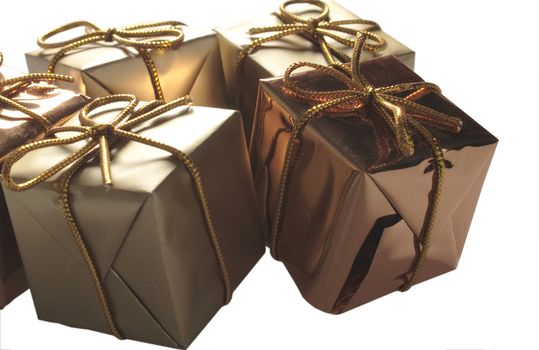 small golden wrapped presents tied with gold string isolated over a white background