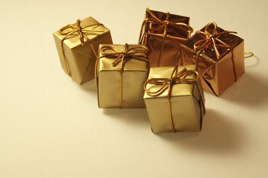 gold coloured  square boxed presents fastened with bows for hanging on the christmas tree
