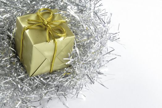 small gold wrapped present on a bed of silver tinsel
