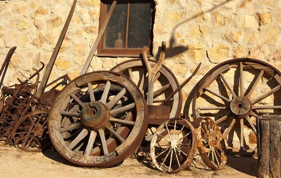 old vintage wheels and machinery outside the blacksmith
