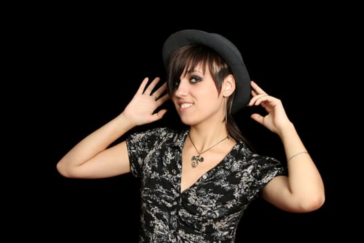 The young smiling girl in a hat, on a black background