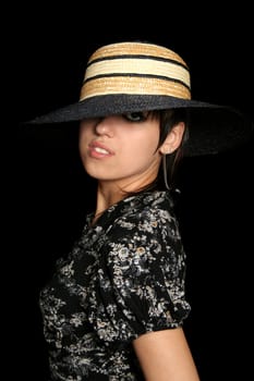 The young girl in a hat, on a black background