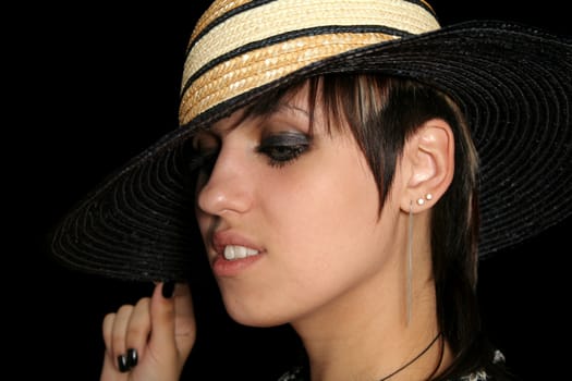 The young girl in a hat, on a black background