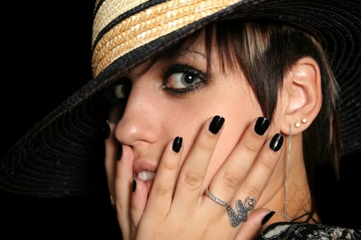 The young beautiful girl in a hat, on a black background