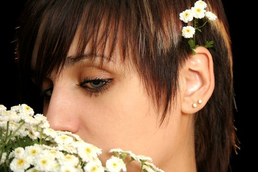 The young beautiful girl with flowers, isolated on a black background