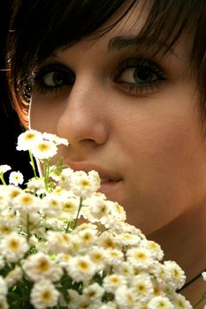 The young beautiful girl with flowers, isolated on a black background