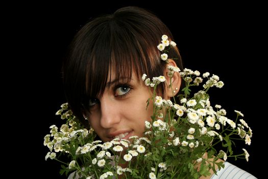 The young beautiful girl with flowers, isolated on a black background