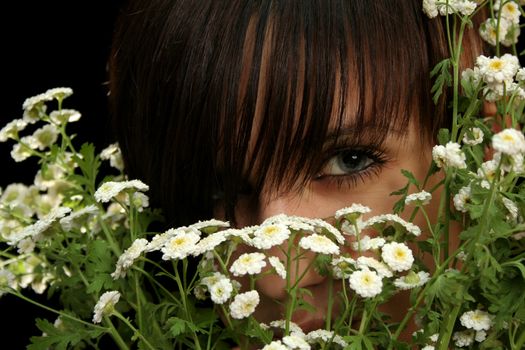 The young beautiful girl with flowers, isolated on a black background