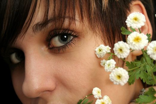 The young beautiful girl with flowers, isolated on a black background