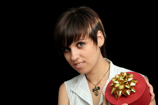 The young girl holds a box with a gift, isolated on black background