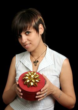 The young girl holds a box with a gift, isolated on black background