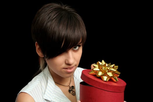 The young girl holds a box with a gift, isolated on black background