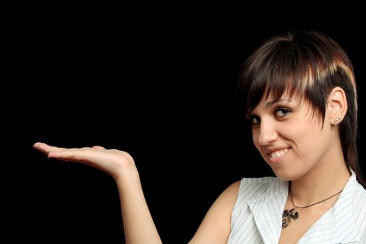 The young girl holds something in a hand, is isolated on a black background