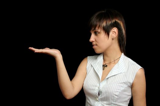 The young girl looks at something in a hand, is isolated on a black background